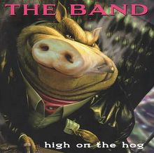 Text oben: "THE BAND". Unten: "high on the hog". Illustration eines Schweins im Anzug mit Zigarette und Geldschein.