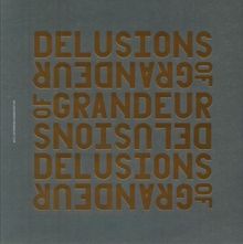 Der Satz "DELUSIONS OF GRANDEUR" ist mehrfach gespiegelt vorhanden. Der Hintergrund ist dunkelgrau.
