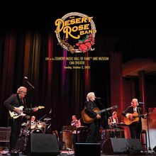 "The Desert Rose Band" Logo, Konzert im CMA Theater, 2. Oktober 2022. Musiker mit Gitarren und bunter Vorhang im Hintergrund.
