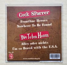 „Cock Sparrer“, „Die Toten Hosen“, Titel von Songs, brauner Hintergrund, www.randaleshop.de, Barcode unten rechts.