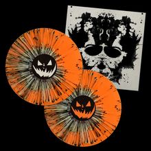 Zwei orangefarbene Schallplatten mit schwarzen, grinsenden Kürbis-Gesichtern vor einer schwarz-weißen Tintenfleck-Illustration.