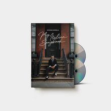 „Giovanni Zarrella My Italian Songbook“. Ein Mann sitzt auf einer Treppe vor einem Backsteingebäude, daneben zwei CDs.