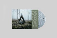 CD-Hülle mit symbolartigen Mustern und einem geometrischen Logo in einem nebligen Wald.