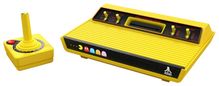 Konsole in leuchtendem Gelb mit Pac-Man und Geistern sowie Atari-Logo. Enthält Hebel und Schalter, gelber Joystick mit rotem Knopf.