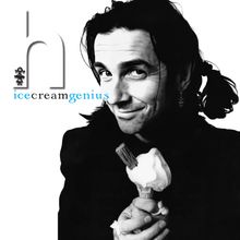Text: "icecreamgenius". Schwarz-weißes Porträt eines lächelnden Mannes mit Eis in der Hand. Linkes Haar zu Zöpfen gebunden.