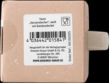 Etikett für eine Tasse „Herzensbecher“ mit Bambusdeckel, Hersteller Droemer Knaur, Barcode, braune Verpackung.
