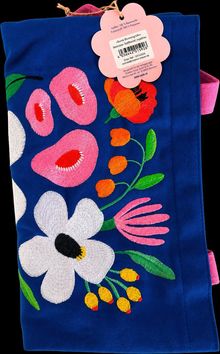 Pinkes Etikett: „Bunte Blumengrüße“. Blaues Stoffteil mit bunten Stickblumen.