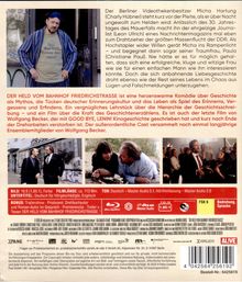 Texte: Der Film "Der Held vom Bahnhof Friedrichstraße" ist eine herzerwärmende Komödie über Geschichte und Mythos.

Im oberen Teil ein Mann im gestreiften Morgenmantel. Darunter zwei kleinere Fotos: Links zwei Männer im Gespräch vor einem Gebäude; rechts ein Mann und eine Frau in einer lebhaften Diskussion. Unten Symbole und Hinweise zur Filmlänge und Tonformaten.