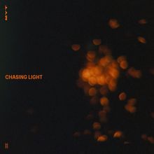 Links steht senkrecht „MYT“, mittig „CHASING LIGHT“ in Orange auf dunklem Hintergrund mit verschwommenen Lichtpunkten.