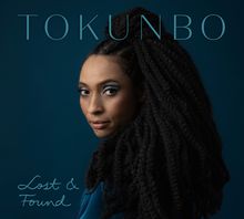 Text: „TOKUNBO“, „Lost & Found“. Eine Frau mit langen Zöpfen blickt über die Schulter, vor tiefblauem Hintergrund.