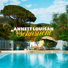 Text: "ANNETT LOUISAN Sehnsucht". Frau auf Liegestuhl am Pool, bunte Vegetation, blauer Himmel.