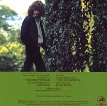 Oben: Titelliste von Liedern wie "LOVE COMES TO EVERYONE".  
Darunter ein Mann im schwarzen Mantel vor grüner Natur.