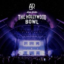 Text: "AJR live from The Hollywood Bowl." Konzertbühne in violettem Licht vor Publikum, unter einem Sternenhimmel.