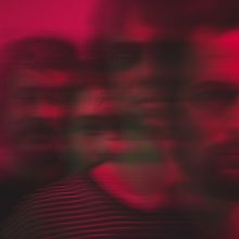 Ich kann keinen Text erkennen. Verschwommene Silhouetten von vier Personen in dunklem Rot- und Rosatönen.