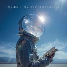 „THE SCRIPT“ und „THE USER’S GUIDE TO BEING HUMAN“ oben. Ein Astronaut liest ein Buch in einer Wüstenlandschaft.