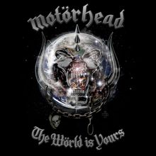 Text: "Motörhead", "The World is Yours". Illustration: Ein furchterregender, metallischer Schädel mit großen Reißzähnen und Ketten.