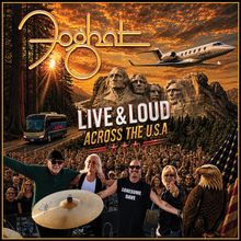 "Live & Loud Across the U.S.A." zeigt eine Band vor Mount Rushmore, mit einem Flugzeug und Bus im Hintergrund.