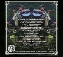 01. WHEN THE TRAIN COME ALONG. Illustration: Mann mit Gitarre, sitzt, umgeben von Pflanzen und Wasser.