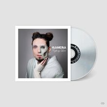 "KAMERA Cyborg Love" in stilisierter Schrift. Ein Mensch, halb Cyborg, trägt weißen Umhang. CD sichtbar.