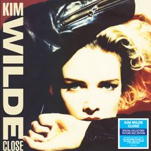 "Kim Wilde Close" steht oben, dazu ein blauer Aufkleber mit Zusatzinfos. Ein Gesicht blickt intensiv hervor.
