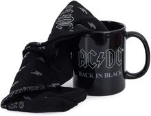 Text "AC/DC BACK IN BLACK" auf schwarzer Tasse, umhüllt von einem schwarzen Kleidungsstück.