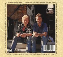 Trackliste: "1. You Never Needed Water, 2. Further Down The Road..." Zwei Männer sitzen vor einem Gebäude und lächeln.