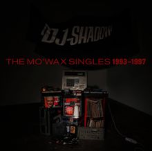 "THE MO'WAX SINGLES 1993–1997" in roter Schrift. Geräte und eine Vinylsammlung, umgeben von Kabeln und einer Maske.