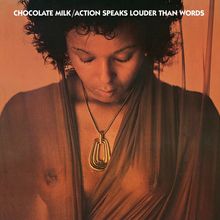 Text: "CHOCOLATE MILK / ACTION SPEAKS LOUDER THAN WORDS". Frau mit geschlossenen Augen und großem Anhänger.