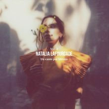 Texte: "Vol. 2 NATALIA LAFOURCADE Un canto por México." Frau hält eine gelbe Blume vor ihrem Gesicht, in weichem Licht.