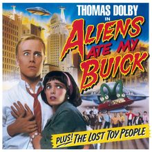 Thomas Dolby in Aliens Ate My Buick. Plus! The Lost Toy People. Besorgtes Paar vor fliegenden Untertassen und Stadt. 