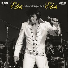 Text: "Elvis That's The Way It Is Elvis", "RCA LSP-4445", "VICTOR STEREO".  
Schwarz-weißes Foto eines Mannes in weißem Anzug mit Mikrofon.