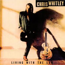 "CHRIS WHITLEY" oben und "LIVING WITH THE LAW" unten. Ein Mann lehnt an einer Wand, neben ihm eine Resonatorgitarre.