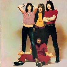 Links steht "GOODBYE", vier Personen in enger Kleidung: zwei stehen, zwei sitzen. Retro-Stil, bunte Kleidung.