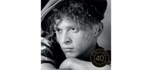 Der Text lautet: "SIMPLY RED 40 RECOLLECTIONS". Schwarz-weißes Porträt eines nachdenklichen Mannes mit lockigem Haar und Hut.