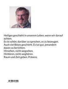 Ein lächelnder Mann trägt ein kariertes Hemd und eine Brille mit einem grauen Bart.