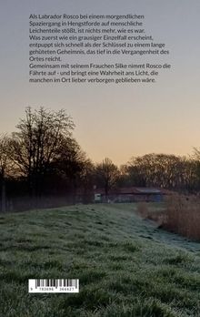 Text: Ein Labrador entdeckt bei einem Spaziergang in Hengstforde Leichenteile, was ein Geheimnis im Ort aufdeckt.  
Szene: Ein morgendlicher Weg neben einem Feld, Bäume und ein Gebäude im Hintergrund.