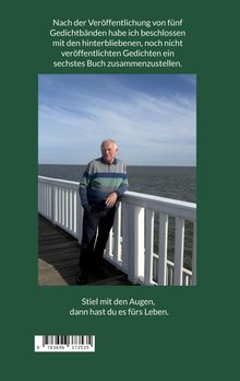 Ein älterer Mann lehnt an einem weißen Geländer an einem Holzsteg am Meer.