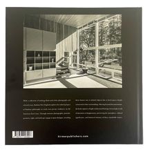 Text: "hirmerpublishers.com"  
Beschreibung: Ein schwarz-weißes Foto eines modernen Innenraums mit großen Fenstern.