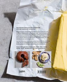 Ein zerknittertes Stück Papier mit einem Text über ein Kochbuch, daneben ein Stück Butter und Bilder von Gebäck und Brot.