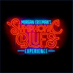 "Morgan Freeman's Symphonic Blues Experience" in leuchtenden Neonfarben, rot und blau, auf schwarzem Hintergrund.