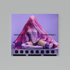MADONNA. CONFESSIONS II. Eine Person sitzt, mit einem transparenten, violetten Schleier, der ihren Kopf bedeckt.