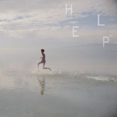 Text: "HELP". Junge läuft im flachen Wasser, Spritzer um ihn, Hintergrund aus Himmel und Wolken.