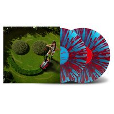 Zwei Schallplatten, eine blau-rot gesprenkelt, eine blau mit roten Details. Eine Frau mäht Smiley-Form in den Rasen.