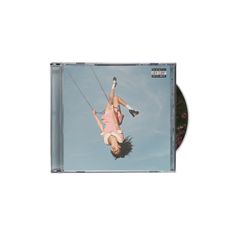 Ein umgedrehtes Foto eines Mädchens auf einer Schaukel, blauer Himmel im Hintergrund, "Parental Advisory"-Label oben rechts.