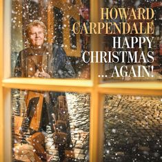 "HOWARD CARPENDALE HAPPY CHRISTMAS ... AGAIN!" Ein Mann blickt lächelnd durch ein Fenster mit fallendem Schnee.