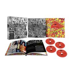 "CREAM Wheels of Fire" steht groß auf zwei schwarz-weißen Boxen. Daneben ein buntes Buch, CDs und ein Booklet.