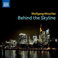 Text: "Wolfgang Mitschke Behind the Skyline." Nachtszene einer beleuchteten modernen Skyline am Wasser. Logo oben links.