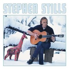 "STEPHEN STILLS" steht oben. Ein Mann spielt Gitarre im Schnee, sitzend auf einer Bank, neben einer bunten Giraffe.
