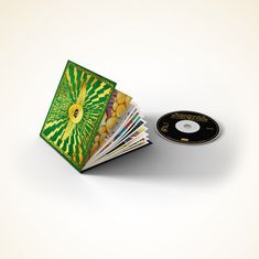 CD rechts, bunte Buchhülle links mit Text "DELIRIUM". Buch zeigt mehrere Doppelseiten mit verschiedenen Designs.