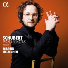 "Schubert Piano Sonatas Volume 1 Martin Helmchen." Ein Mann mit Brille und Bart, in schwarz gekleidet, vor orangenem Hintergrund.